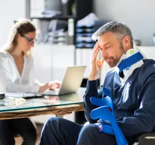 a man in a wheelchair who suffered from a neck injury consulting with an attorney