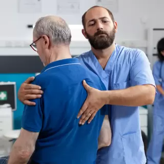 A doctor examining a man who has had a spinal cord injury in the past