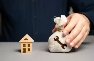 Custom home budget represented by a house and a money bag with a repairs symbol
