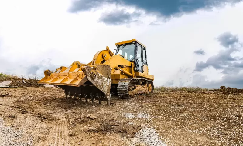 Bulldozer clearing rural lot for a custom home.