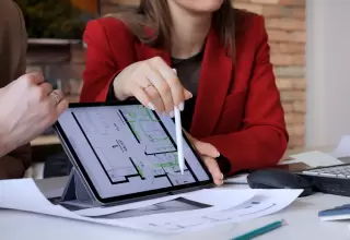 Homeowners discussing floor plans and new construction mortgage options with a builder.