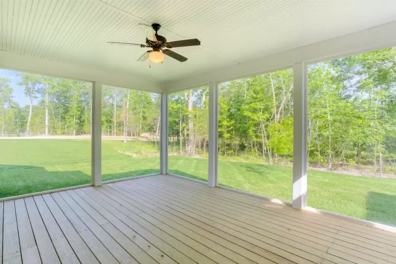 Covered back porch designed for Gulf Coast living with ceiling fans and outdoor seating