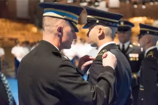 Officer apply a Record of Performance patch on military personnel