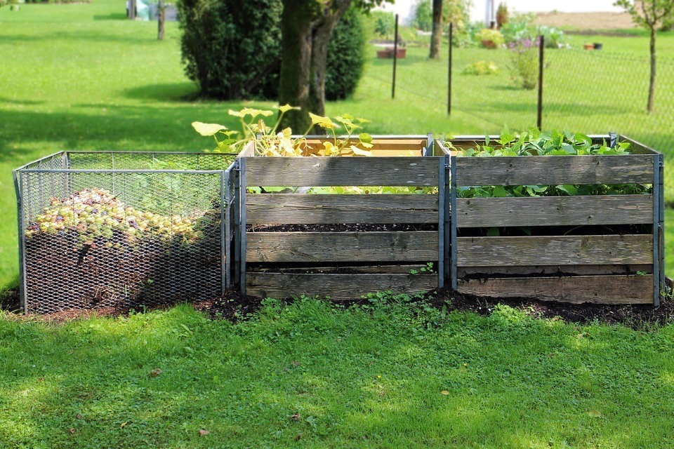 Predator Guard compost in wooden and metal containers placed in yard