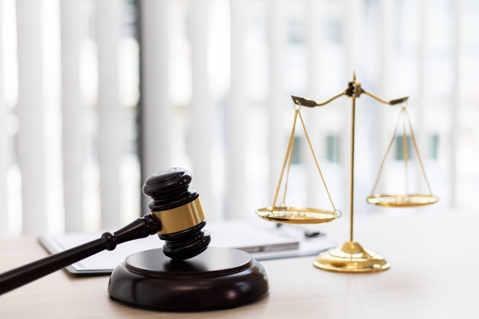 Gavel resting across a sound block along with symbolic court weighing scale 