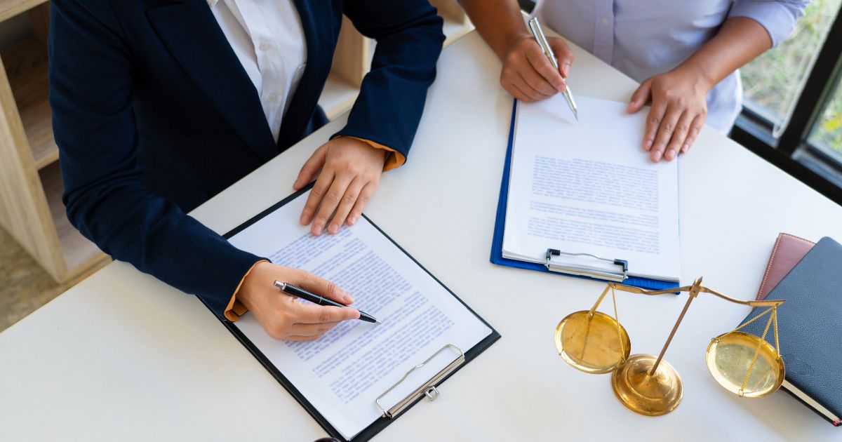 two people at a table with documents