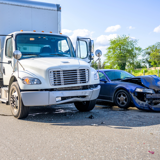 A commercial truck next to a wrecked car