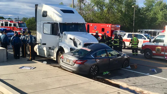 White semi truck crashed into the side of a gray car