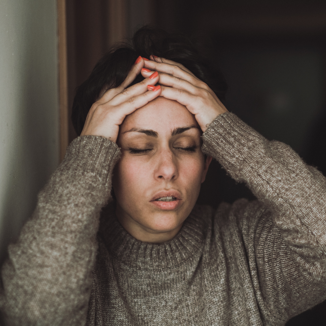 Sad woman with head in her hands