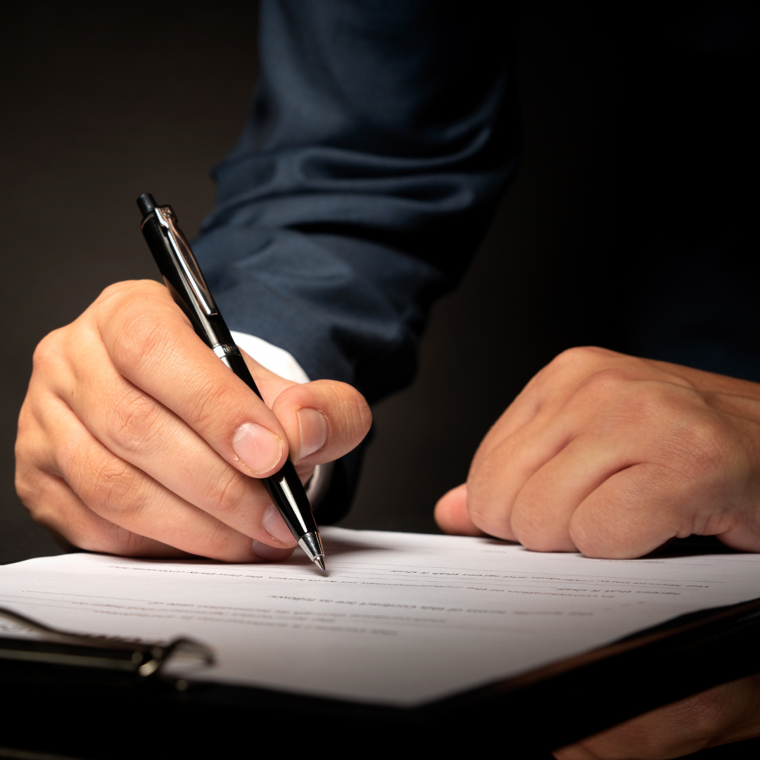 Lawyer holding pen signing docs