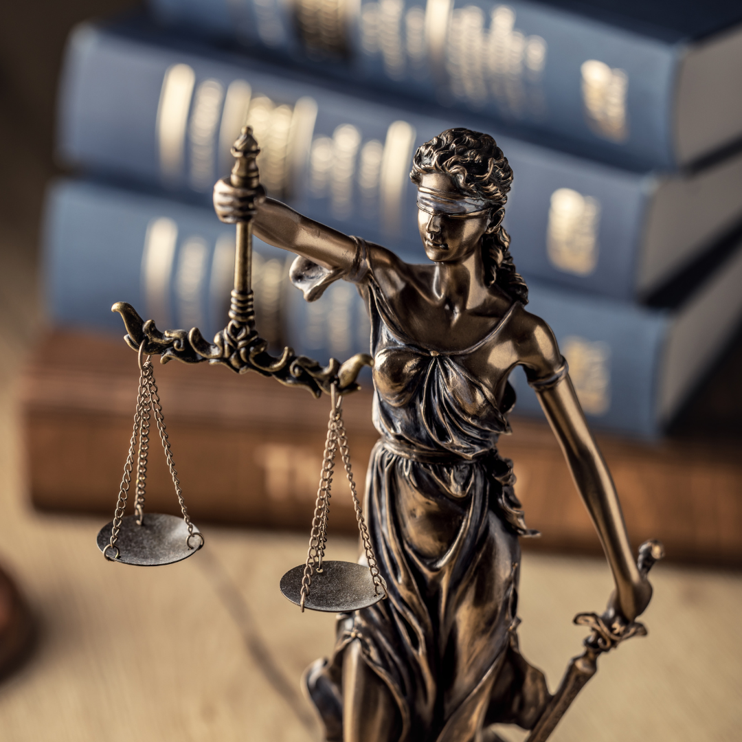 Lady Justice figurine in front of legal books