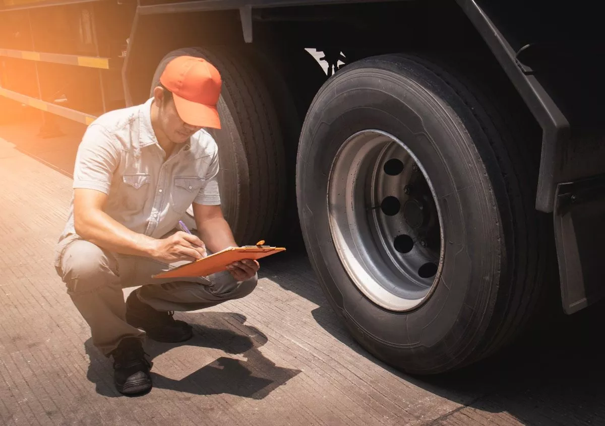 Truck driver inspecting semi truck tires