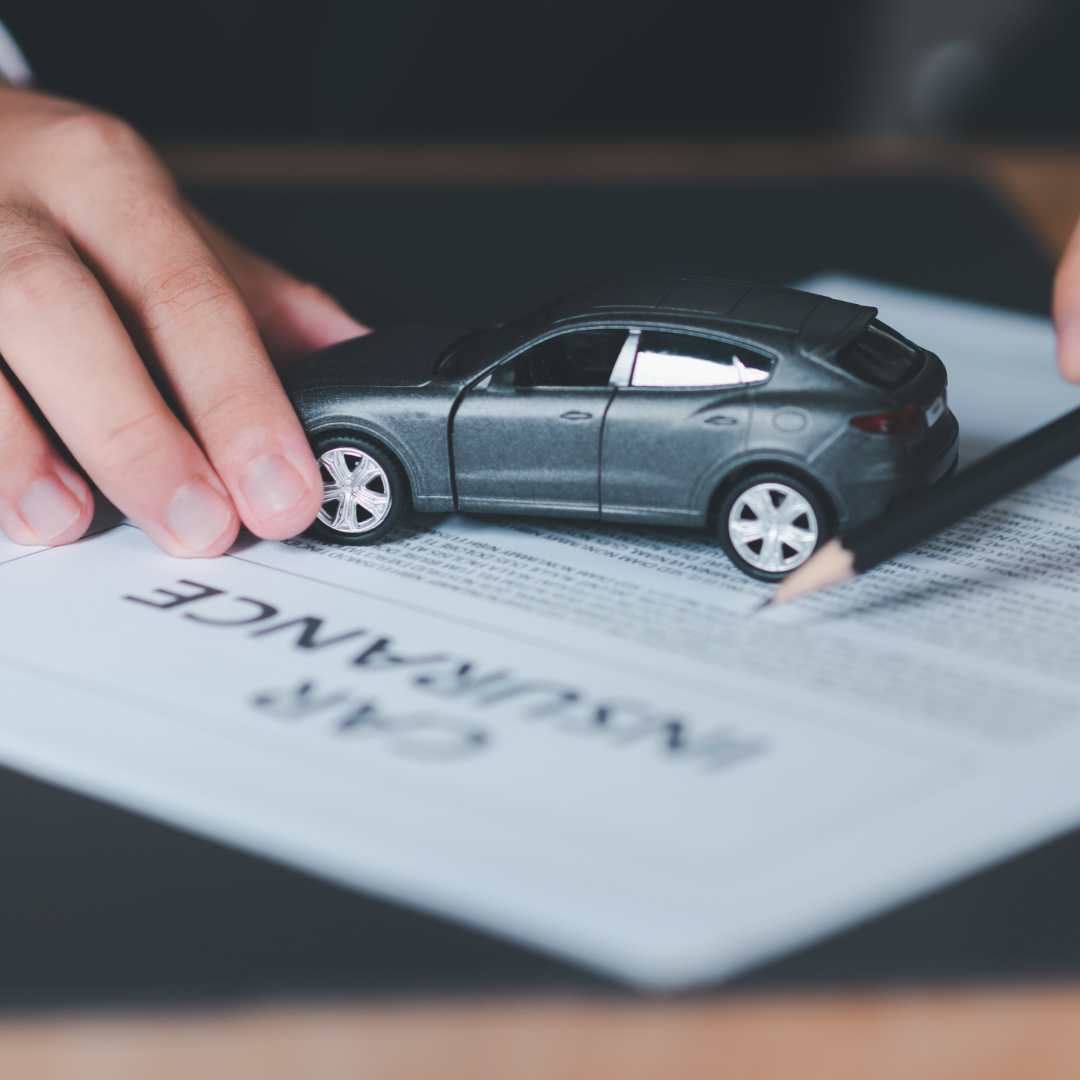 A model car on top of auto insurance documents