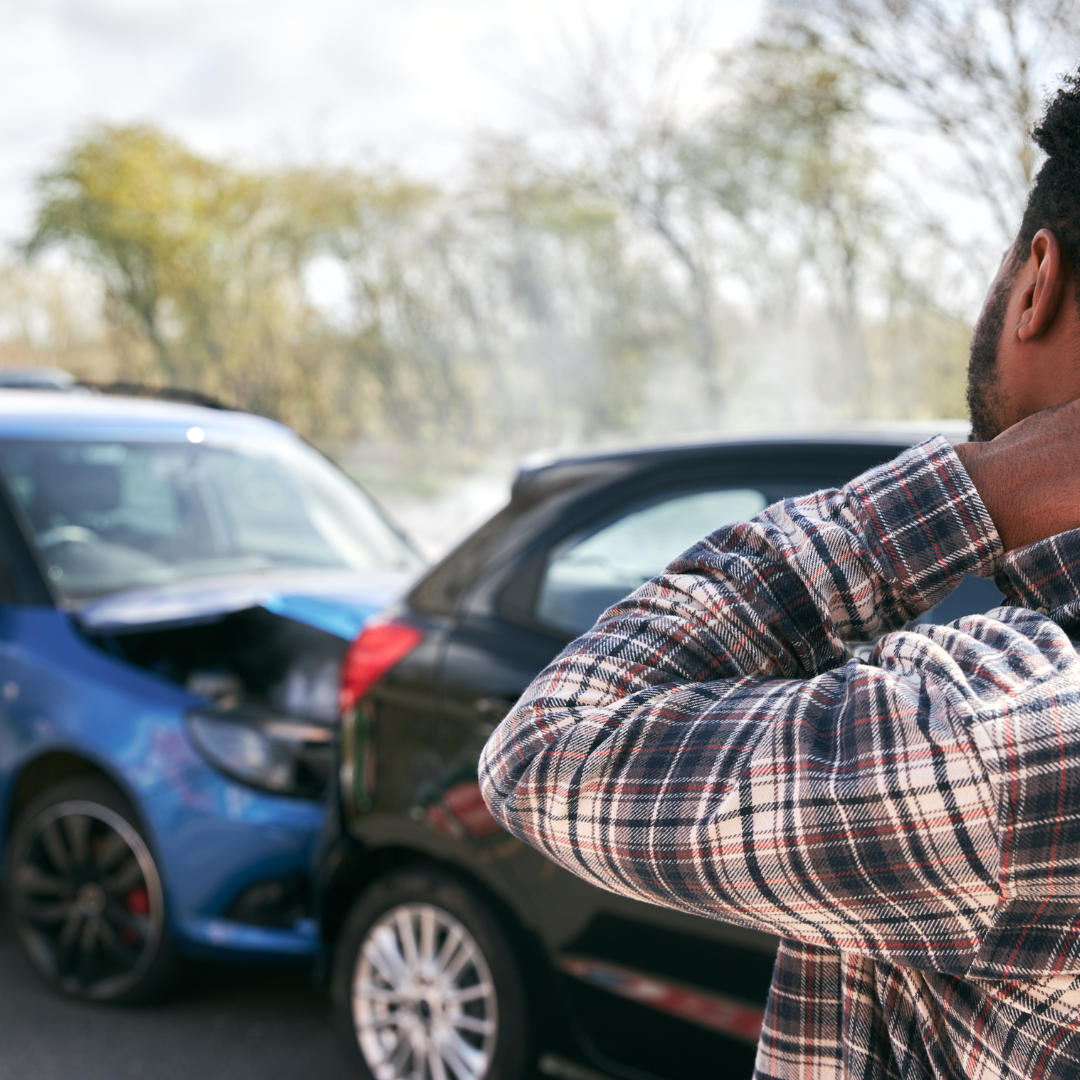 Man looking at 2 cars in a crash