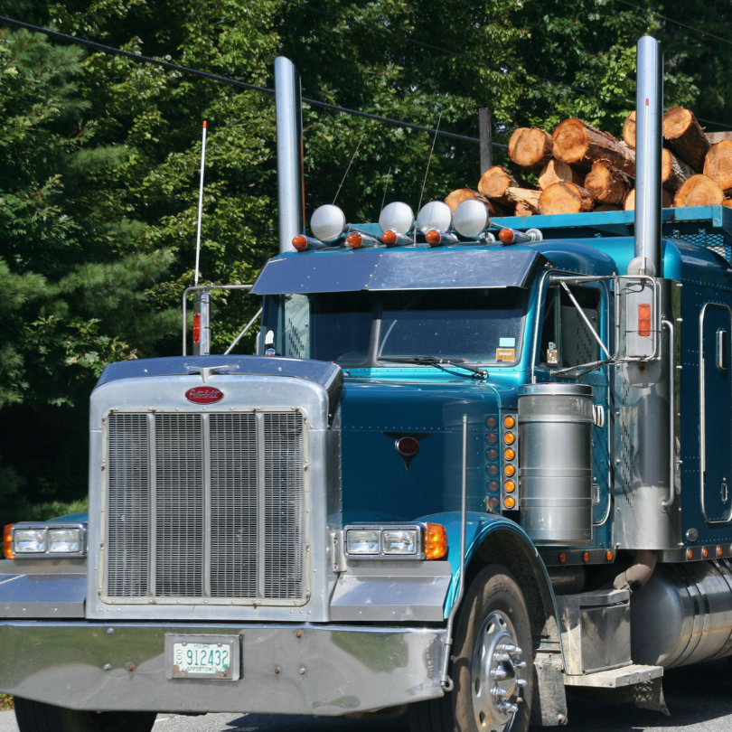 Blue logging truck hauling logs